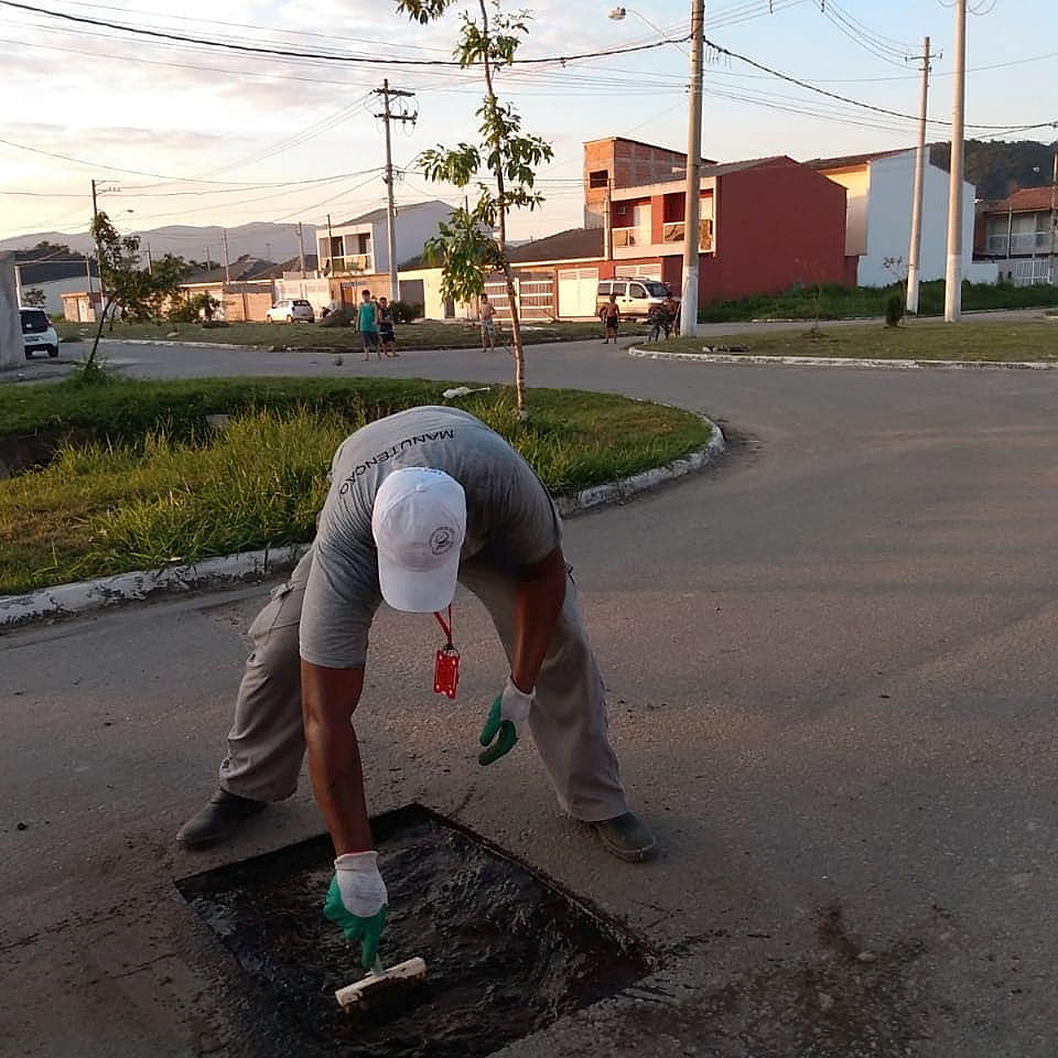 Trabalhadores do Residencial Victoria Park revitalizando o asfalto.