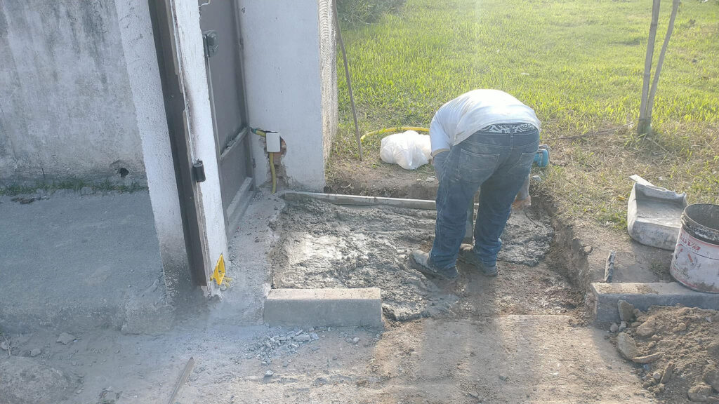 Obra de rebaixamento de guia para acessibilidade no portão social do Residencial Victoria Park.